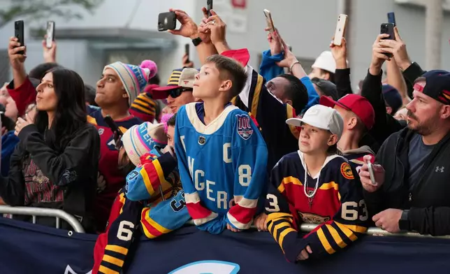 Fans watch as Florida Panthers players arrive before the NHL Winter Classic outdoor hockey game between the Florida Panthers and the New York Rangers, Friday, Jan. 2, 2026, in Miami. (AP Photo/Lynne Sladky)