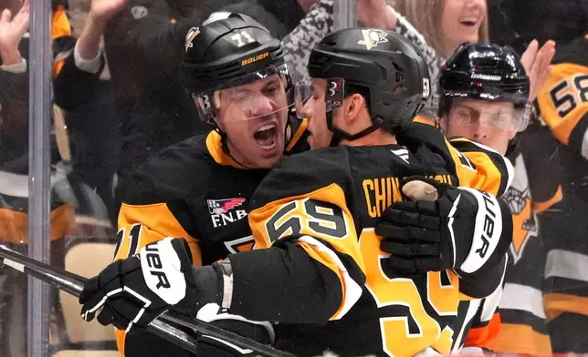 Pittsburgh Penguins' Egor Chinakhov (59) celebrates with Evgeni Malkin (71) after scoring during the second period of an NHL hockey game against the Calgary Flames in Pittsburgh, Saturday, Jan. 10, 2026. (AP Photo/Gene J. Puskar)