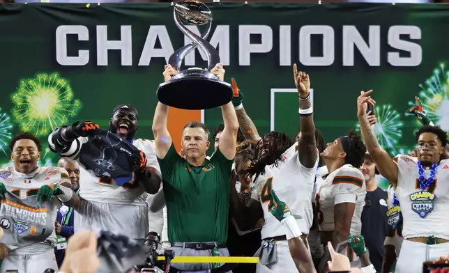 Miami head coach Mario Cristobal holds the Field Scovell Trophy following the Cotton Bowl College Football Playoff quarterfinal game against Ohio State Wednesday, Dec. 31, 2025, in Arlington, Texas. (AP Photo/Gareth Patterson)