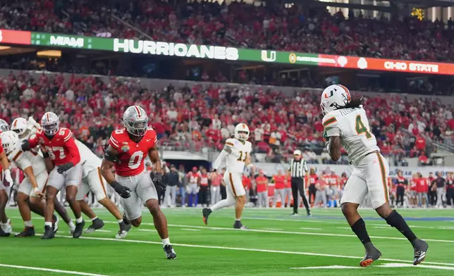 Miami running back Mark Fletcher Jr. (4) catches a pass from quarterback Carson Beck (11) before running int in for a touchdown in front of Ohio State linebacker Sonny Styles (0) during the first half of the Cotton Bowl College Football Playoff quarterfinal game Wednesday, Dec. 31, 2025, in Arlington, Texas. (AP Photo/Julio Cortez)