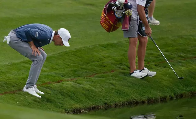 David Puig of Spain and his caddie look for the ball on 4th hole during the final round of the Dubai Desert Classic in United Arab Emirates, Sunday, Jan. 25, 2026. (AP Photo/Altaf Qadri)