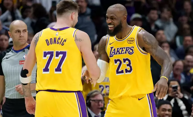 Los Angeles Lakers forward/guard Luka Dončić (77) celebrates a three point basket with forward LeBron James (23) against the New Orleans Pelicans during the second half of an NBA basketball game in New Orleans, Tuesday, Jan. 6, 2026. (AP Photo/Matthew Hinton)