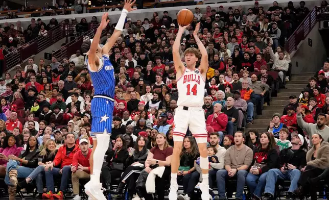 Chicago Bulls forward Matas Buzelis, right, shoots a 3-point basket over Orlando Magic guard Anthony Black during the second half of an NBA basketball game Friday, Jan. 2, 2026, in Chicago. (AP Photo/David Banks)