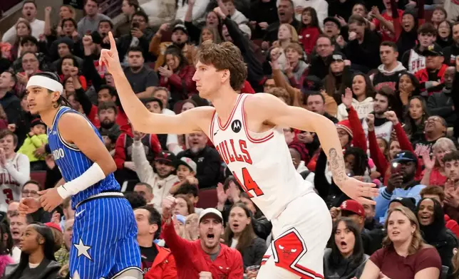 Chicago Bulls forward Matas Buzelis, right, gestures after making a 3-point basket over Orlando Magic guard Anthony Black, left, during the second half of an NBA basketball game, Friday, Jan. 2, 2026, in Chicago. (AP Photo/David Banks)
