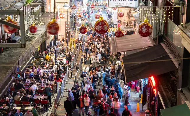 People gather at Lan Kwai Fong to celebrate the start of 2026 in the Central district of Hong Kong, Wednesday, Dec. 31, 2025. (AP Photo/Chan Long Hei)
