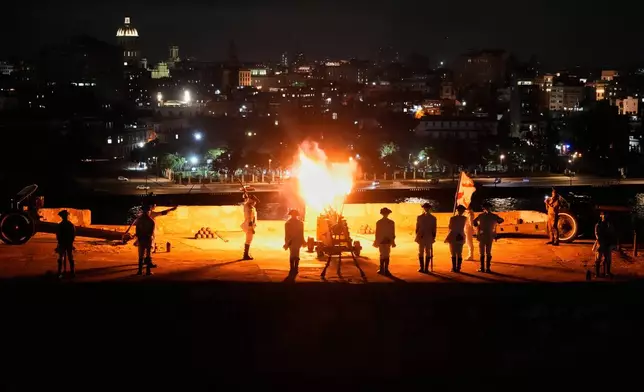 Soldiers dressed in historical uniforms fire a cannon during a nightly ceremony at San Carlos de la Cabaña Fortress in Havana, Monday, Jan. 26, 2026. (AP Photo/Ramon Espinosa)