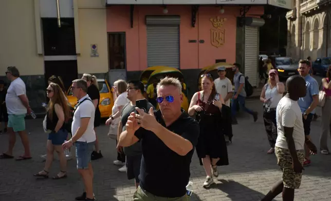 Tourists traverse a street in Havana, Monday, Jan. 26, 2026. (AP Photo/Ramon Espinosa)