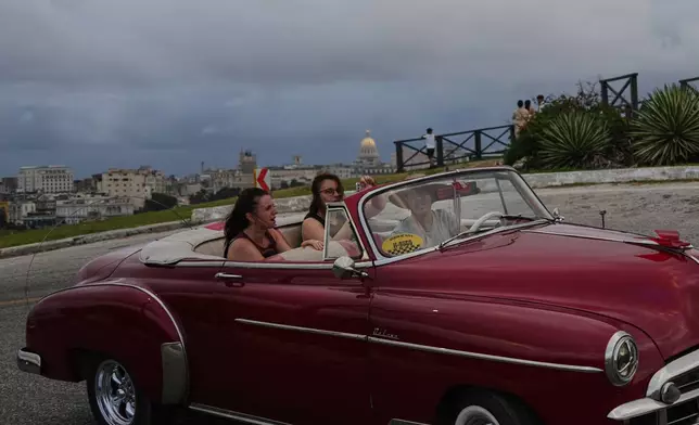 Tourists take a ride in a classic American car in Havana, Monday, Jan. 26, 2026. (AP Photo/Ramon Espinosa)