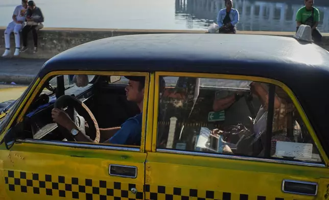 A taxi drives customers in Havana, Monday, Jan. 26, 2026. (AP Photo/Ramon Espinosa)