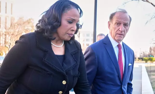 Federal Reserve governor Lisa Cook and attorney Abbe Lowell, arrive at the Supreme Court in Washington, Wednesday, Jan. 21, 2026. (AP Photo/Mark Schiefelbein)
