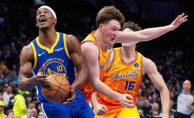 Golden State Warriors forward Jimmy Butler III drives to the basket past Charlotte Hornets guard Kon Knueppel during the first half of an NBA basketball game, Wednesday, Dec. 31, 2025, in Charlotte, N.C. (AP Photo/Chris Carlson)
