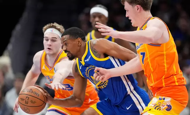 Golden State Warriors guard De'Anthony Melton drives to the basket between Charlotte Hornets guard Liam McNeeley and guard Kon Knueppel during the first half of an NBA basketball game, Wednesday, Dec. 31, 2025, in Charlotte, N.C. (AP Photo/Chris Carlson)