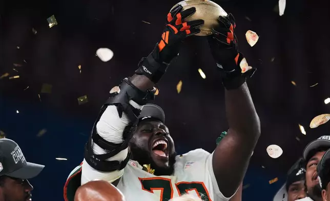 Miami offensive lineman Markel Bell holds up a trophy after winning the Fiesta Bowl NCAA college football playoff semifinal game against Mississippi, Thursday, Jan. 8, 2026, in Glendale, Ariz. (AP Photo/Ross D. Franklin)