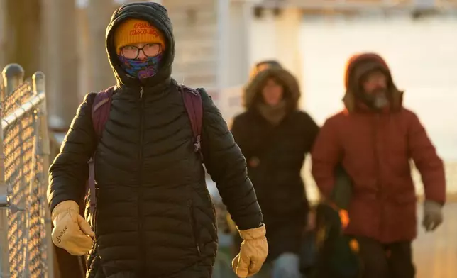 Island commuters are bundled against the cold as they disembark from a ferry on a 1-degree F. morning, Saturday, Jan. 24, 2026, in Portland, Maine. (AP Photo/Robert F. Bukaty)