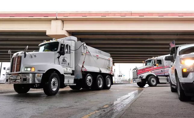 Work crews stage with de-icing materials in their trucks ahead of expected inclement weather in Plano, Texas, Friday, Jan. 23, 2026. (AP Photo/Tony Gutierrez)
