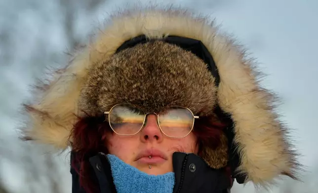 Emma Nadeau, of North Yarmouth, Maine, is bundled against the cold as she watches the sunrise on a 1-degree F. morning, Saturday, Jan. 24, 2026, in Portland, Maine. (AP Photo/Robert F. Bukaty)
