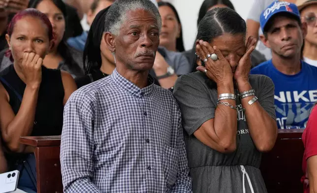 Relatives of soldiers killed in the U.S. raid to capture Venezuelan President Nicolas Maduro and his wife mourn during the soldiers' funeral in Caracas, Venezuela, Wednesday, Jan. 7, 2026. (AP Photo/Ariana Cubillos)