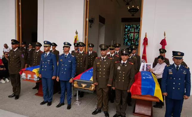 Military personnel stand by the coffins of soldiers killed in the U.S. capture of Venezuelan President Nicolas Maduro and his wife during the soldiers' funeral in Caracas, Venezuela, Wednesday, Jan. 7, 2026. (AP Photo/Ariana Cubillos)