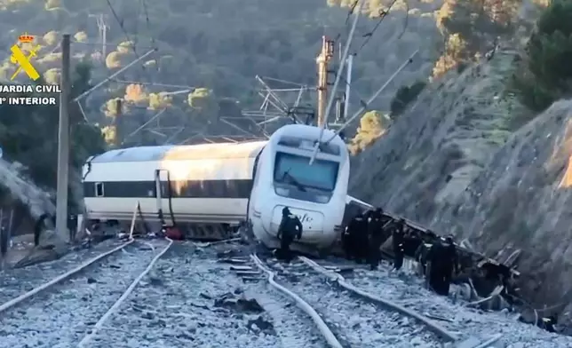 In this grab taken from video provided by Guardia Civil, rescue workers at the scene after a high speed train collision, in Adamuz, Spain, Monday, Jan. 19, 2026. (Guardia Civil via AP)
