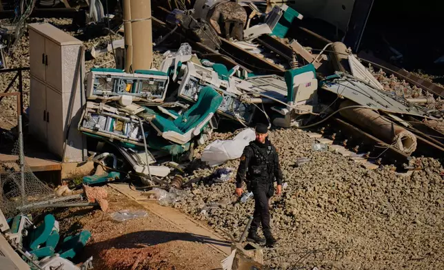 Guardia Civil officers collect evidence next to the wreckage of train cars involved in a collision in Adamuz, southern Spain, Tuesday, Jan. 20, 2026. (AP Photo/Manu Fernandez)