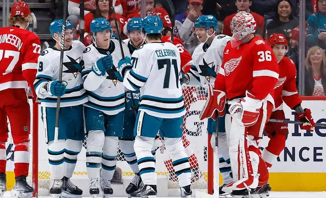 San Jose Sharks center Will Smith (2) celebrates with defenseman Dmitry Orlov (9), left wing Pavol Regenda (84) and center MacKlin Celebrini (71) after scoring against Detroit Red Wings goaltender John Gibson (36) during the first period of an NHL hockey game Friday, Jan. 16, 2026, in Detroit. (AP Photo/Duane Burleson)