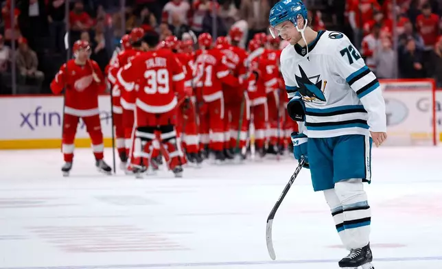 San Jose Sharks left wing William Eklund (72) skates off the ice as Detroit Red Wings players celebrate their win after an NHL hockey game Friday, Jan. 16, 2026, in Detroit. (AP Photo/Duane Burleson)