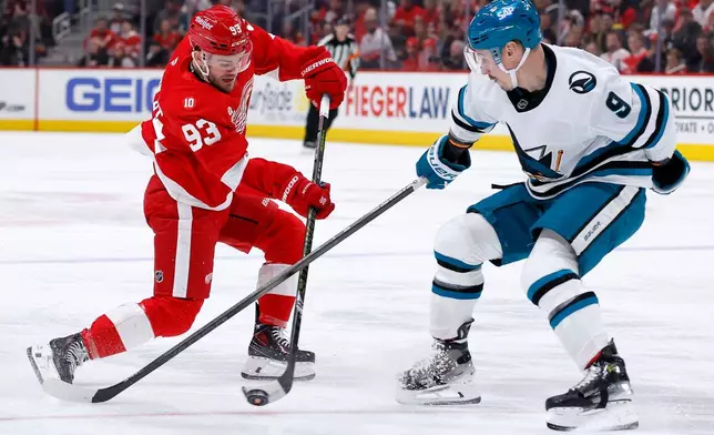 Detroit Red Wings right wing Alex DeBrincat (93) shoots on goal against San Jose Sharks defenseman Dmitry Orlov (9) during the first period of an NHL hockey game Friday, Jan. 16, 2026, in Detroit. (AP Photo/Duane Burleson)