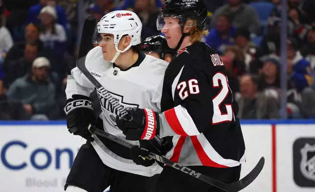 Los Angeles Kings left wing Jeff Malott, left, and Buffalo Sabres defenseman Rasmus Dahlin (26) battle for position during the second period of an NHL hockey game, Thursday, Jan. 29, 2026, in Buffalo, N.Y. (AP Photo/Jeffrey T. Barnes)