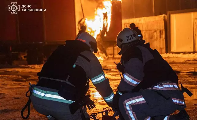 In this photo provided by the Ukrainian Emergency Service, emergency services personnel work to extinguish a fire following a Russian attack in Kharkiv, Ukraine, Tuesday, Jan. 13, 2026. (Ukrainian Emergency Service via AP)