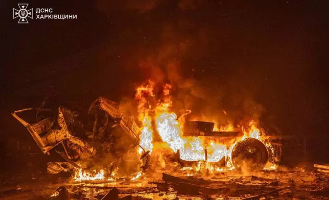 In this photo provided by the Ukrainian Emergency Service, emergency services personnel work to extinguish a fire following a Russian attack in Kharkiv, Ukraine, Tuesday, Jan. 13, 2026. (Ukrainian Emergency Service via AP)