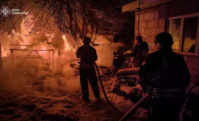 In this photo provided by the Ukrainian Emergency Service, emergency services personnel work to extinguish a fire following a Russian attack in Kyiv region, Ukraine, Tuesday, Jan. 13, 2026. (Ukrainian Emergency Service via AP)