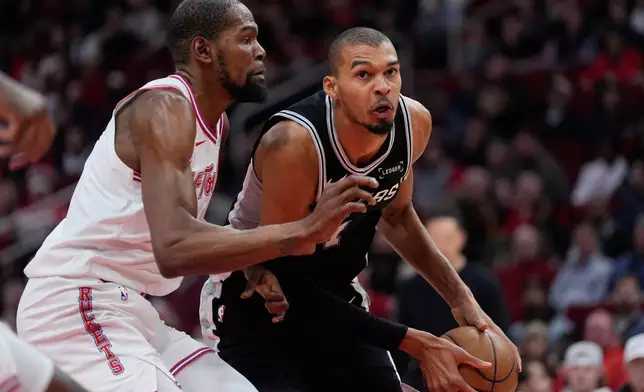 Houston Rockets forward Kevin Durant, left, defends against San Antonio Spurs forward Victor Wembanyama (1) during the first half of an NBA basketball game in Houston, Wednesday, Jan. 28, 2026. (AP Photo/Ashley Landis)