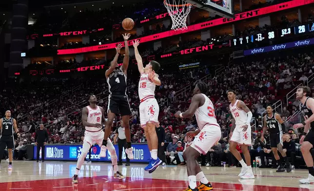 San Antonio Spurs guard De'aaron Fox (4) shoots against Houston Rockets guard Reed Sheppard (15) during the first half of an NBA basketball game in Houston, Wednesday, Jan. 28, 2026. (AP Photo/Ashley Landis)
