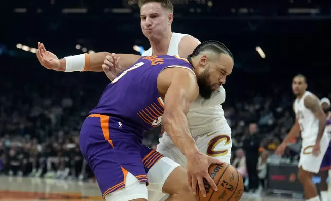 Phoenix Suns forward Dillon Brooks, right, is fouled by Cleveland Cavaliers guard Sam Merrill during the first half of an NBA basketball game Friday, Jan. 30, 2026, in Phoenix. (AP Photo/Ross D. Franklin)