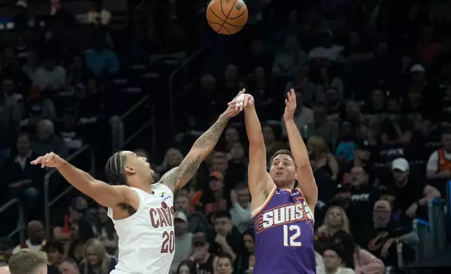 Phoenix Suns guard Collin Gillespie (12) shoots over Cleveland Cavaliers guard Jaylon Tyson (20) during the first half of an NBA basketball game Friday, Jan. 30, 2026, in Phoenix. (AP Photo/Ross D. Franklin)