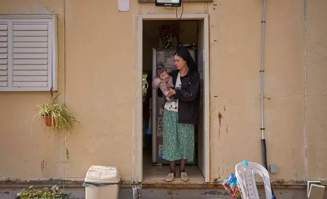 An Israeli settler and her child are seen in the newly-legalized Jewish settlement of Yatziv, adjacent to the Palestinian town of Beit Sahour, in the West Bank, Jan. 19, 2026. (AP Photo/Ohad Zwigenberg)