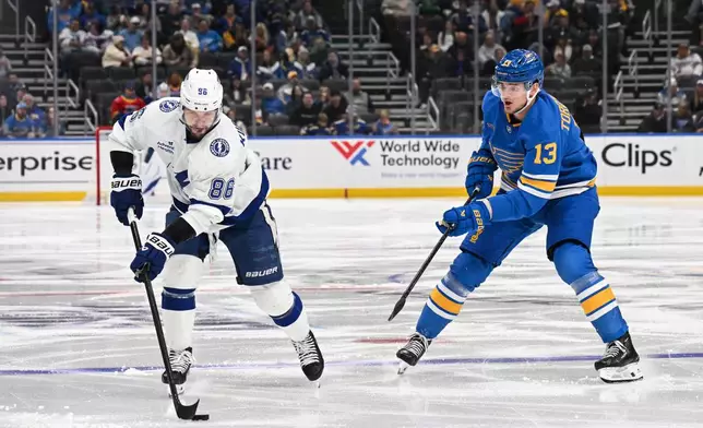St. Louis Blues' Alexey Toropchenko (13) watches as Tampa Bay Lightning's Nikita Kucherov (86) handles the puck during the third period of an NHL hockey game Friday, Jan. 16, 2026, in St. Louis. (AP Photo/Connor Hamilton)