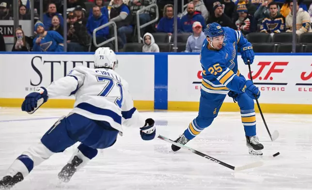 Tampa Bay Lightning's Anthony Cirelli, left, defends as St. Louis Blues' Jordan Kyrou (25) shoots during the second period of an NHL hockey game Friday, Jan. 16, 2026, in St. Louis. (AP Photo/Connor Hamilton)