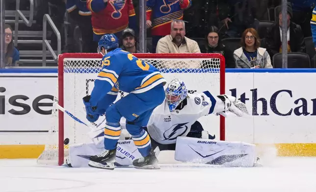 St. Louis Blues' Jordan Kyrou, left, scores the winning goal past Tampa Bay Lightning goaltender Andrei Vasilevskiy, right, in a shootout during an NHL hockey game Friday, Jan. 16, 2026, in St. Louis. (AP Photo/Connor Hamilton)