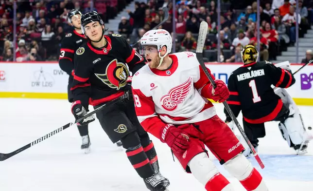 Detroit Red Wings' Andrew Copp, second from right, celebrates his goal on Ottawa Senators' goaltender Leevi Merilainen during the first period of an NHL hockey game in Ottawa, Ontario, Monday, Jan. 5, 2026. (Spencer Colby/The Canadian Press via AP)