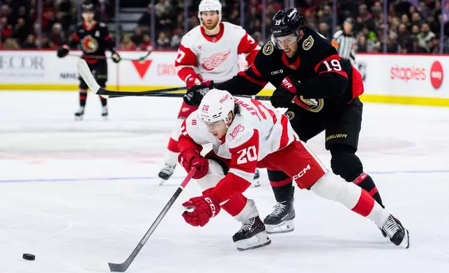 Ottawa Senators' Drake Batherson (19) cross-checks Detroit Red Wings' Albert Johansson (20) as they vie for the puck during second-period NHL hockey game action in Ottawa, Ontario, Monday, Jan. 5, 2026. (Spencer Colby/The Canadian Press via AP)