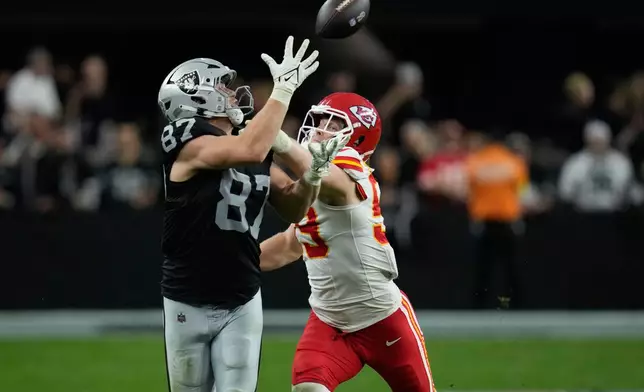 Las Vegas Raiders tight end Michael Mayer (87) catches a pass as Kansas City Chiefs linebacker Cooper McDonald defends during the second half of an NFL football game Sunday, Jan. 4, 2026, in Las Vegas. (AP Photo/John Locher)