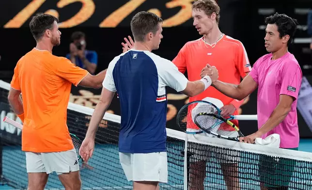 Christian Harrison, left, of the U.S. and Neal Skupski of Britain are congratulated by Australia's Jason Kubler, right, and Marc Polmans after winning the men's doubles final at the Australian Open tennis championship in Melbourne, Australia, Saturday, Jan. 31, 2026. (AP Photo/Asanka Brendon Ratnayake)