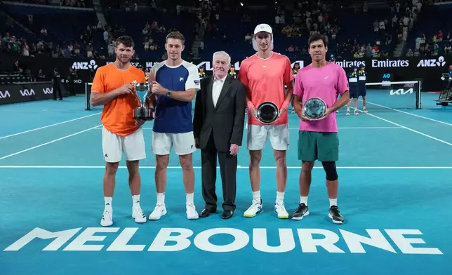 Ken Rosewall, centre, stands with Christian Harrison, left, of the U.S. and Neal Skupski of Britain after they defeated Australia's Jason Kubler, right, and Marc Polmans in the men's doubles final at the Australian Open tennis championship in Melbourne, Australia, Saturday, Jan. 31, 2026. (AP Photo/Aaron Favila)