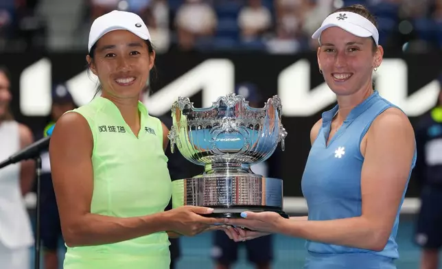 Elise Mertens of Belgium and Zhang Shuai, left, of China pose with their trophy after defeating Anna Danilina of Kazakhstan and Aleksandra Krunic of Serbia in the women's doubles final at the Australian Open tennis championship in Melbourne, Australia, Saturday, Jan. 31, 2026. (AP Photo/Aaron Favila)