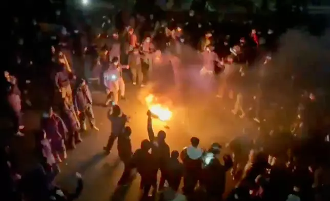 In this frame grab from footage circulating on social media shows protesters dancing and cheering around a bonfire as they take to the streets despite an intensifying crackdown as the Islamic Republic remains cut off from the rest of the world, in Tehran, Iran, Friday, Jan. 9, 2026.(UGC via AP)