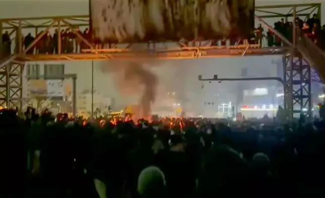In this frame grab from footage circulating on social media from Iran shows protesters taking to the streets despite an intensifying crackdown as the Islamic Republic remains cut off from the rest of the world in Tehran, Iran, Friday, Jan. 9, 2026.(UGC via AP)