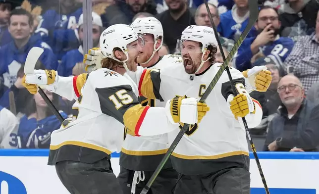 Vegas Golden Knights' Jack Eichel (9), Noah Hanifin (15) and Mark Stone (61) celebrate after a goal against the Toronto Maple Leafs during third-period NHL hockey game action in Toronto, Friday, Jan. 23, 2026. (Nathan Denette/The Canadian Press via AP)