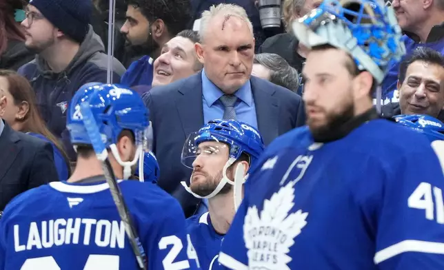 Toronto Maple Leafs head coach Craig Berube, center top, with a black eye and stitches from a gym incident, looks on during first-period NHL hockey game action against the Vegas Golden Knights in Toronto, Friday, Jan. 23, 2026. (Nathan Denette/The Canadian Press via AP)
