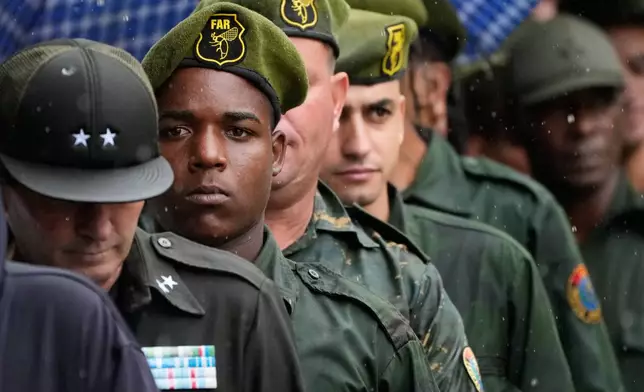 Military members line up outside the Ministry of the Revolutionary Armed Forces where the urns containing the remains of Cuban officers, killed during the U.S. operation in Venezuela that captured President Nicolas Maduro, are on display in Havana, Cuba, Thursday, Jan. 15, 2026. (AP Photo/Ramon Espinosa)